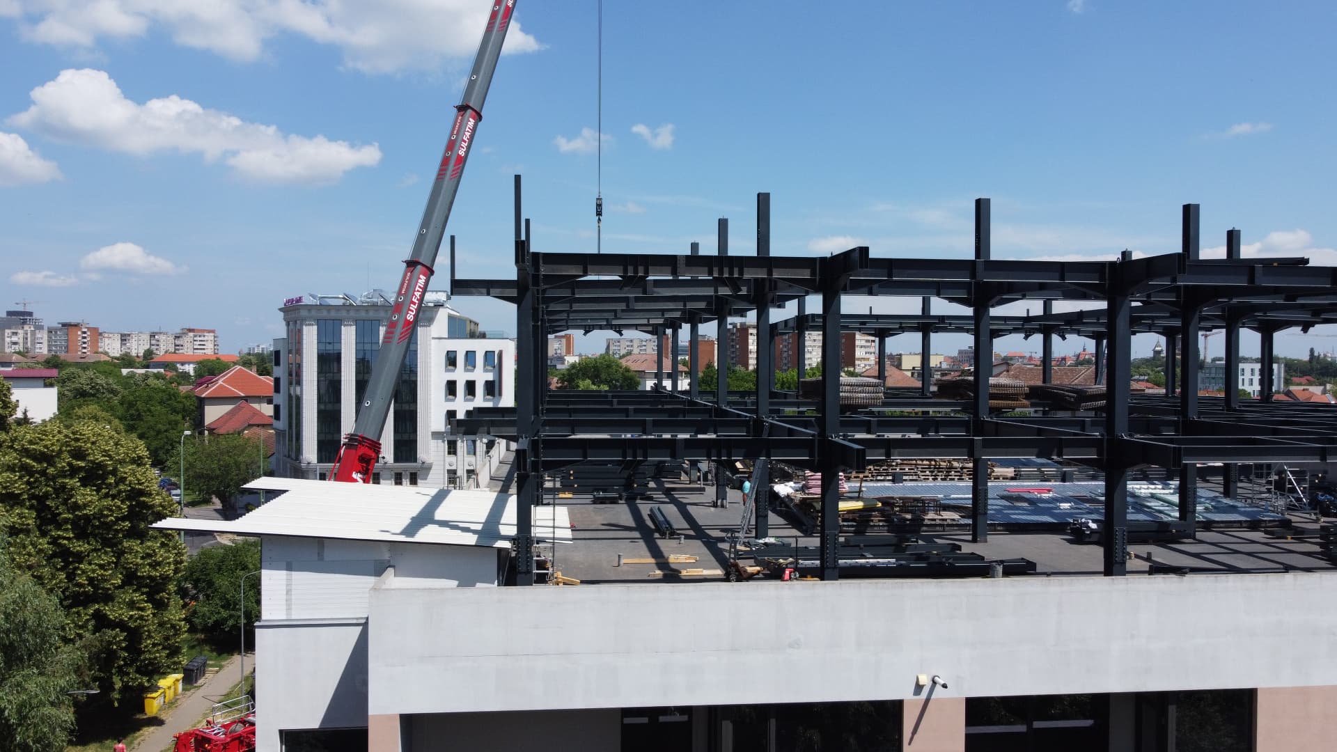 Structura metalica Carrefour: Detaliu al cadrelor metalice montate la nivelul acoperisului, cu macaraua in lucru.